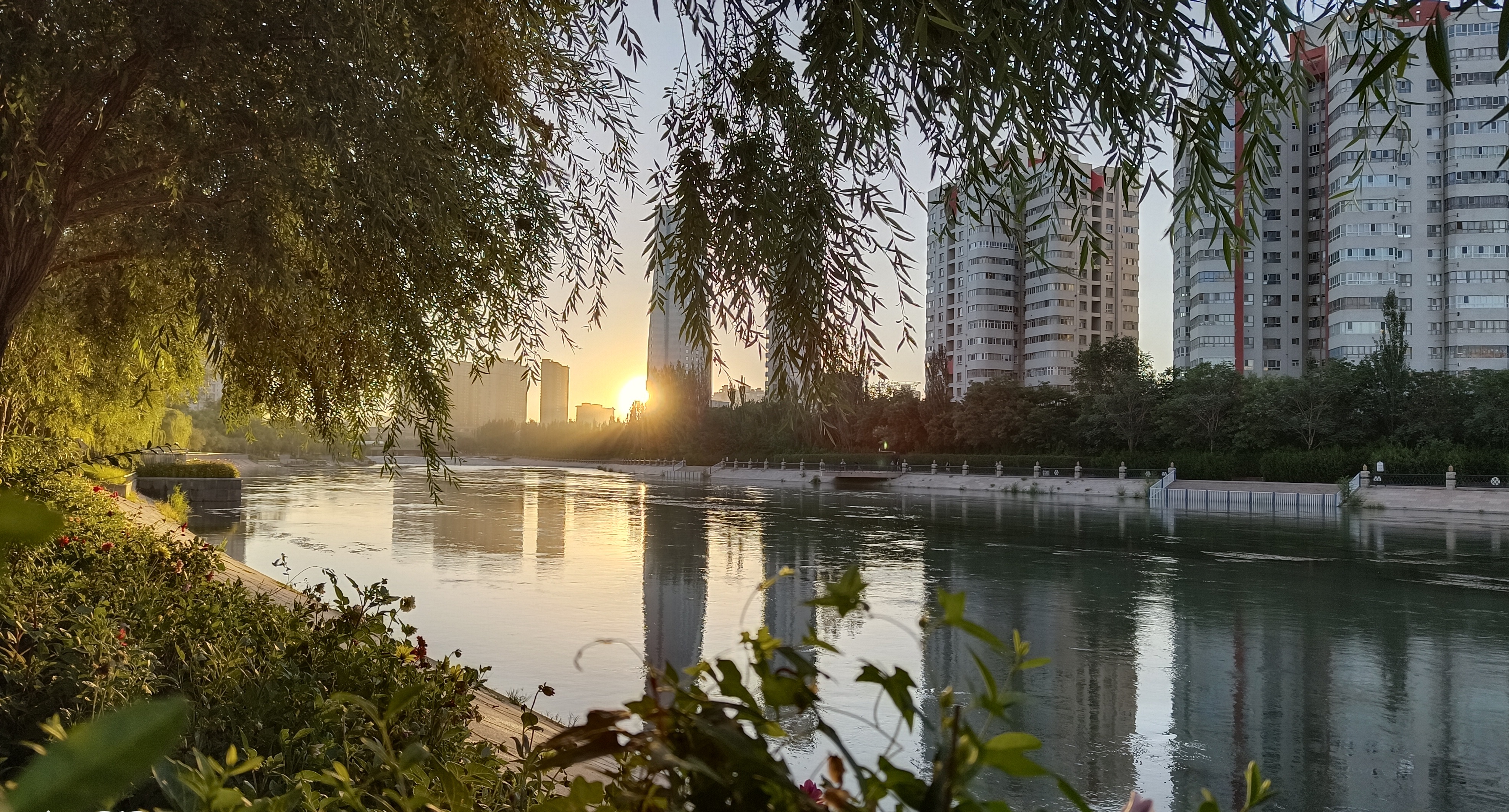 7.立秋时节，草木渐黄，秋意渐渐降临梨城，孔雀河岸上的落日余晖都变得温柔起来，在橘黄色霞光的映照下，呈现出一幅秋日静好的人间仙境画面。（库尔勒市纪委监委 杨杰 摄）.jpg